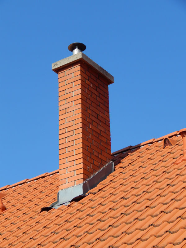 masonry chimney with exposed flashing and metal cap