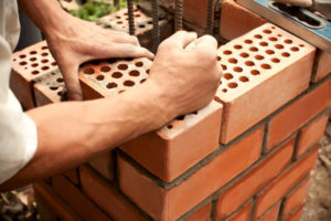 hands working on masonry chimney repairs